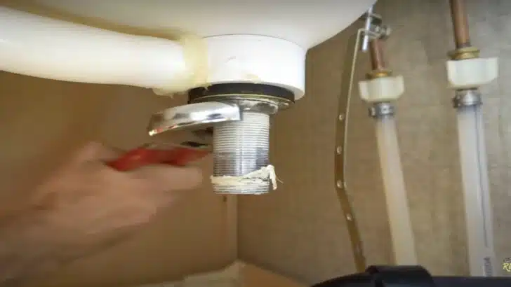 Loosening the nut under the sink