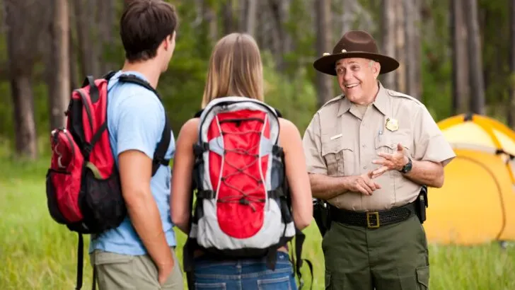 A park ranger talking with two hikers
