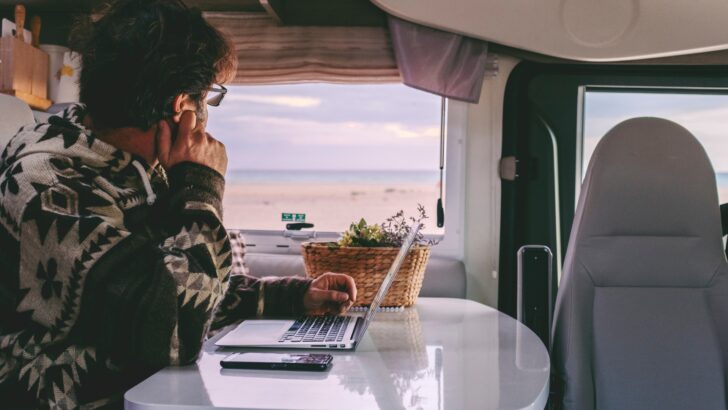 A woman looking out the window from inside a small RV