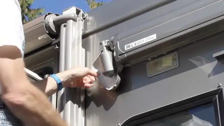 Back of motor cover hanging in place during a Dometic Oasis Elite door awning motor repair/replacement.