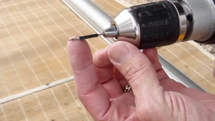 The end of a drill bit wrapped with electrical tape to prevent over-drilling during the installation of an RV window awning.