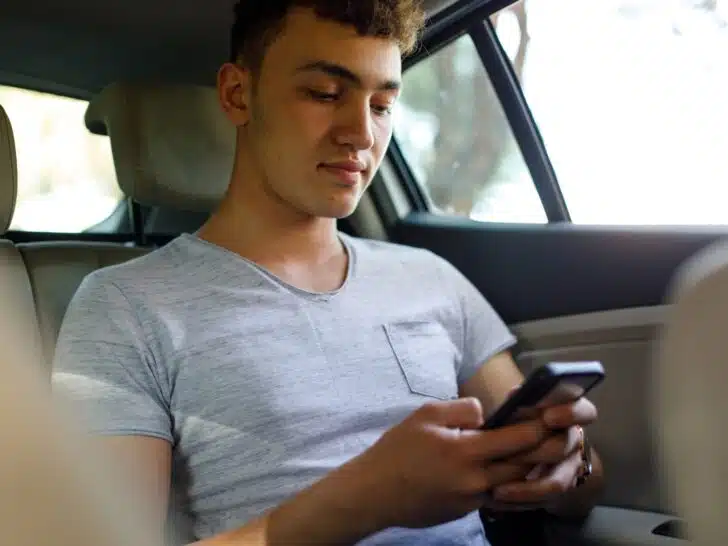 A backseat passenger using a cell phone to connect to stereo via Bluetooth